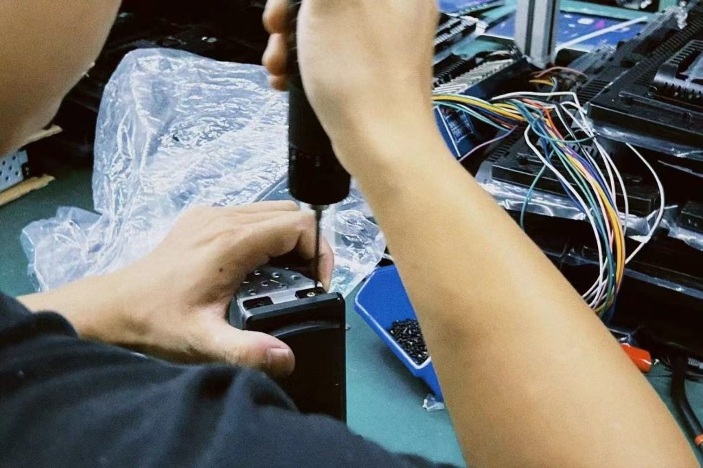 فني يقوم باختبار لوحة العدادات الرقمية الخاصة بمركبة معينة على منضدة الاختبار أثناء مراجعة الضمان